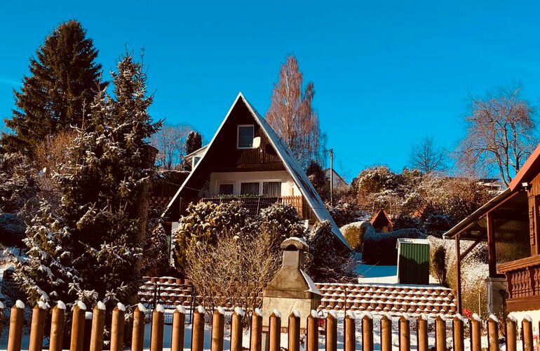 Außenansicht Ferienhaus mit Spitzdach im Winter