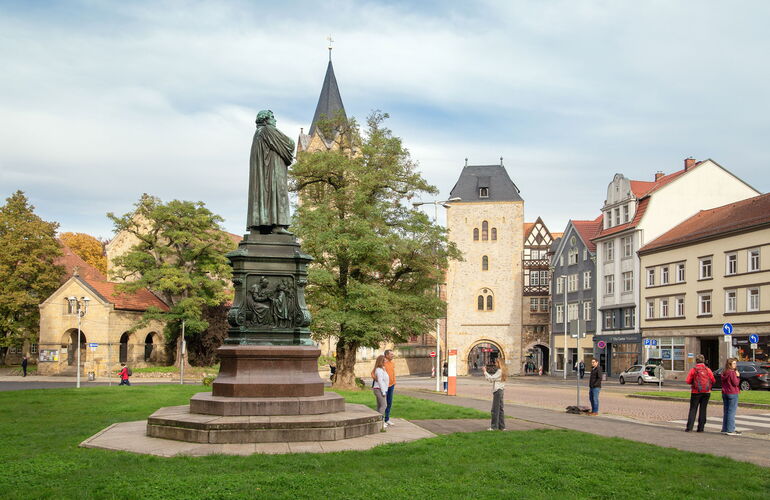 Das Lutherdenkmal auf dem Karlsplatz in Eisenach - im Hintergrund Nikolaikirche und Nikolaitor