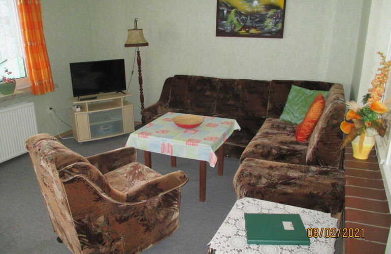 Wohnzimmer mit Sofa, Tisch und Fernseher