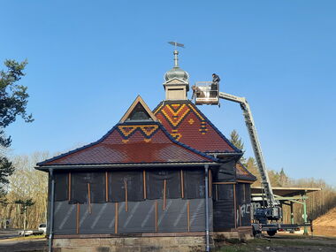 Die Turmhaube mit Wetterfahne wird auf den Fürstenpavillon aufgesetzt