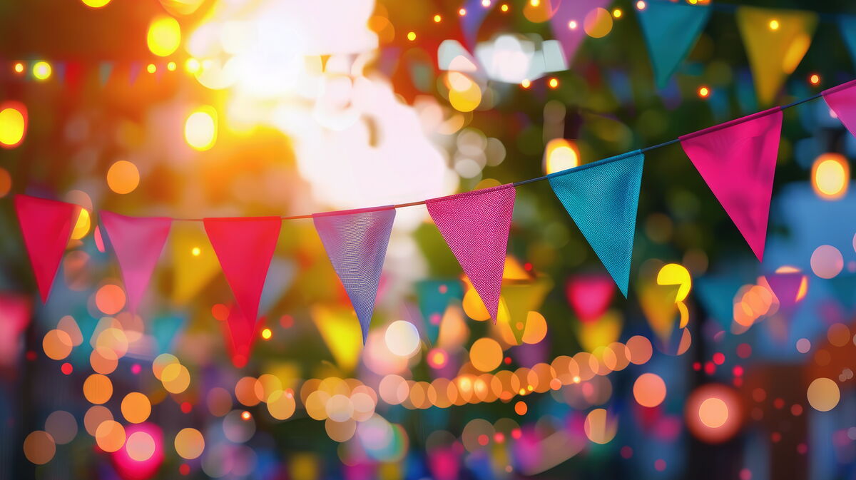 beautiful blurred background of a festive city street with colorful flags and garlands in pink and blue colors AdobeStock_845357814