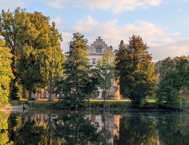 Das Schloss spiegelt sich im See im Park Reinhardsbrunn