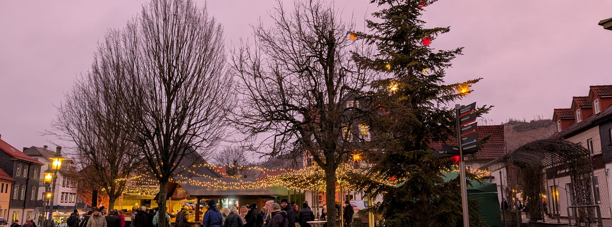 erleuchteter Kirchplatz mit Ständen und Menschen