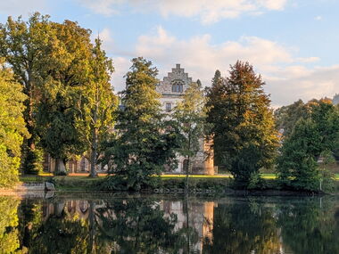Das Schloss spiegelt sich im See im Park Reinhardsbrunn