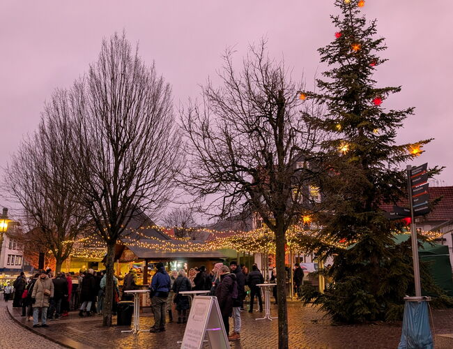 erleuchteter Kirchplatz mit Ständen und Menschen